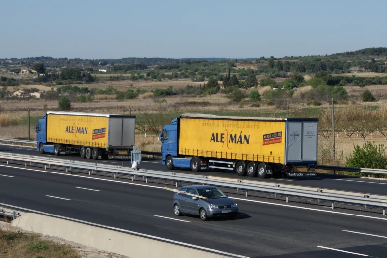 truck traveling on the highway next to a car