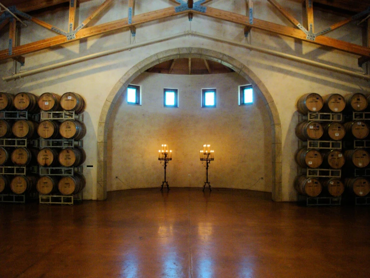 a dimly lit room with many wine barrels