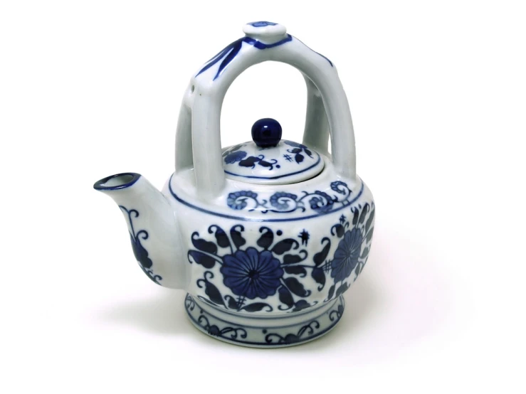 a blue and white ceramic tea kettle with flower pattern