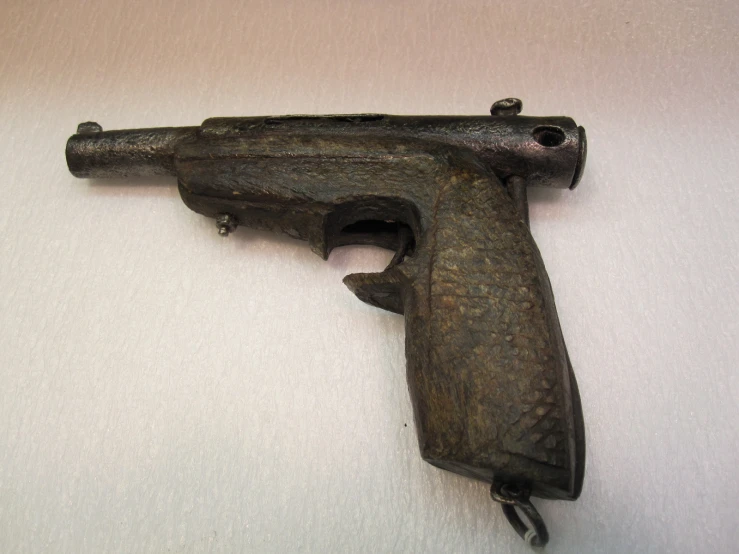 an old black gun that is laying on the wall