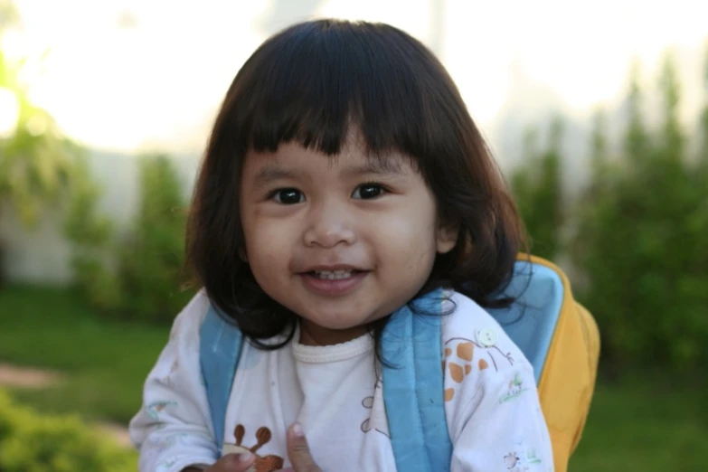 a young child holding onto a banana with a smile