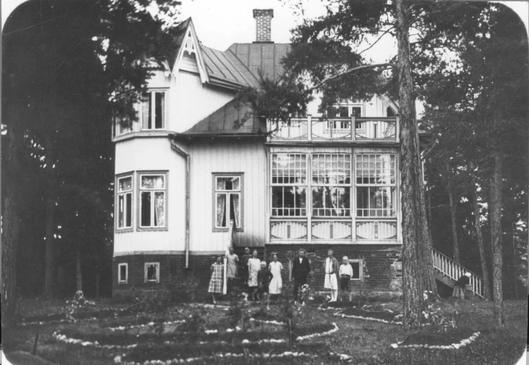 a black and white po of people in front of a house