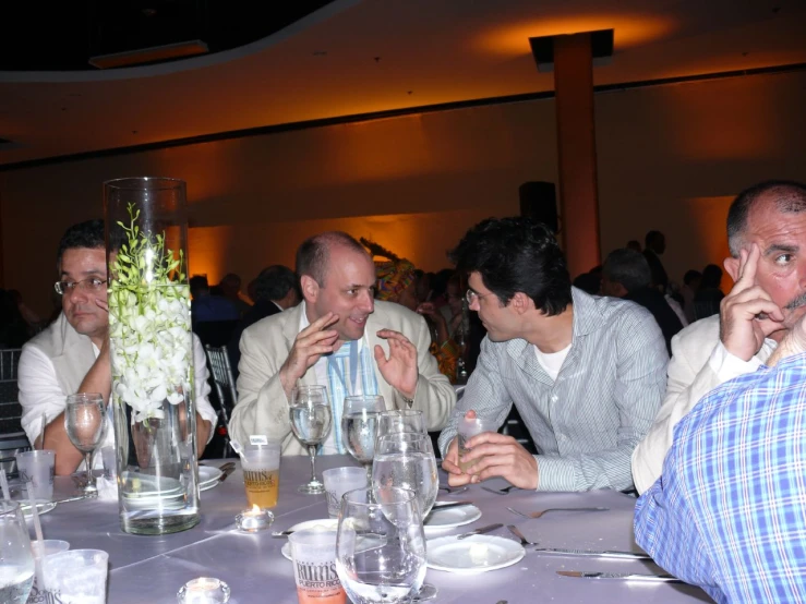 several men sitting at a table with wine glasses