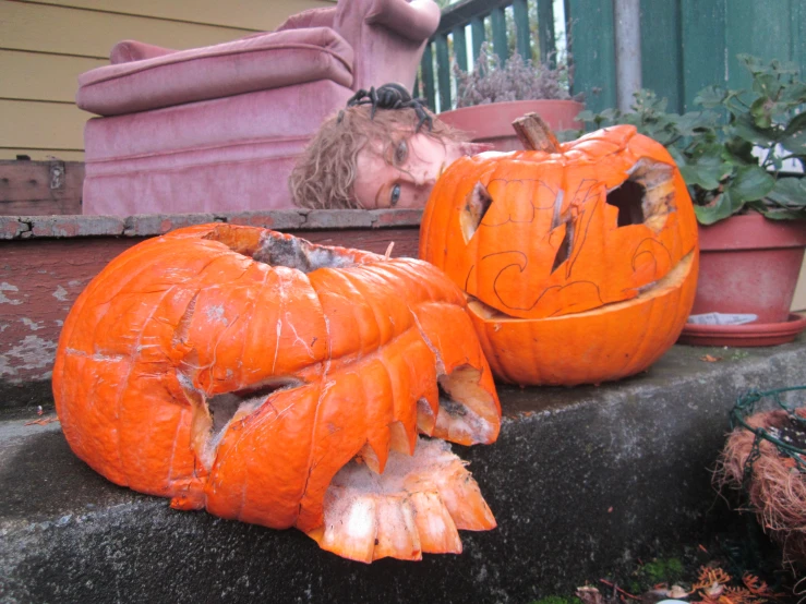 two fake pumpkins with faces cut out of them