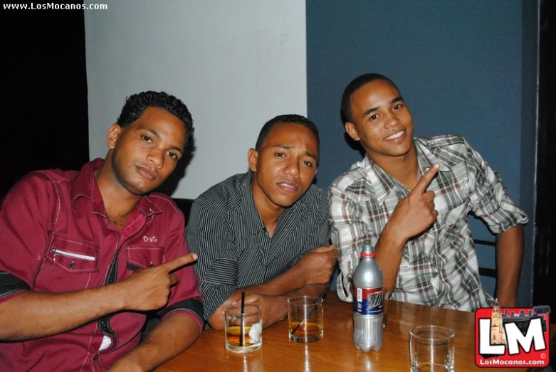 three men at the table with beer in their hand