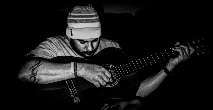 a man sitting on the floor playing a guitar