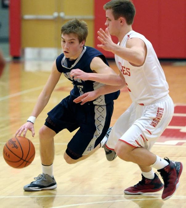 two young men playing basketball against each other