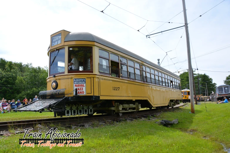 the trolley is carrying passengers on three levels and sits on some tracks