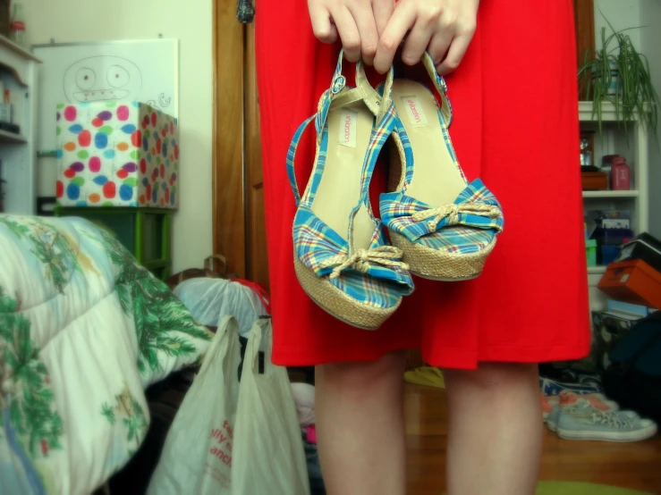 a woman's hand with a pair of shoes