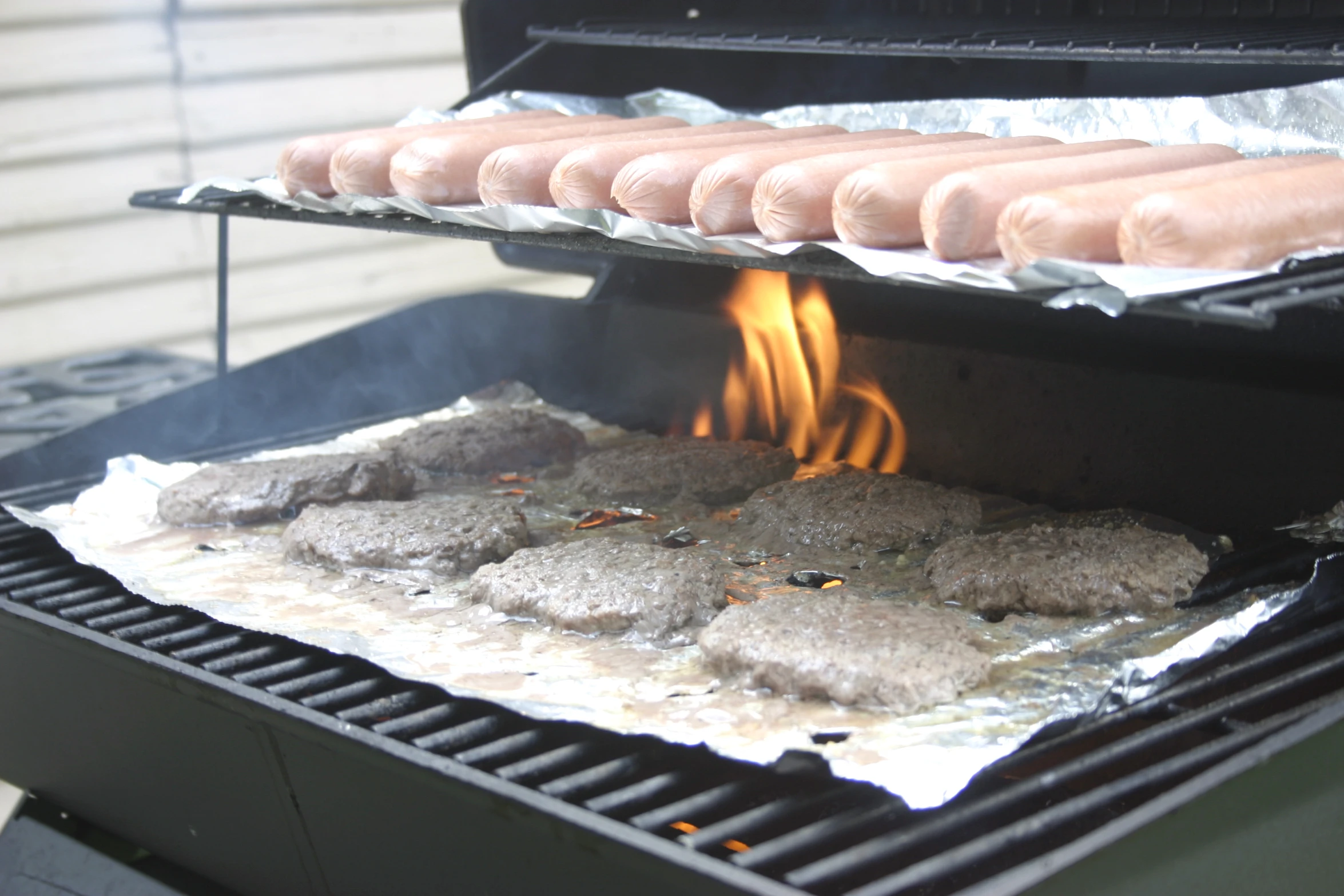 a  dog grill is set up with four sausages on it