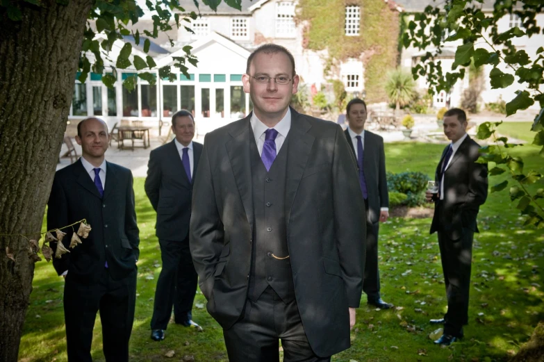 a group of men in suits and ties are standing in a field