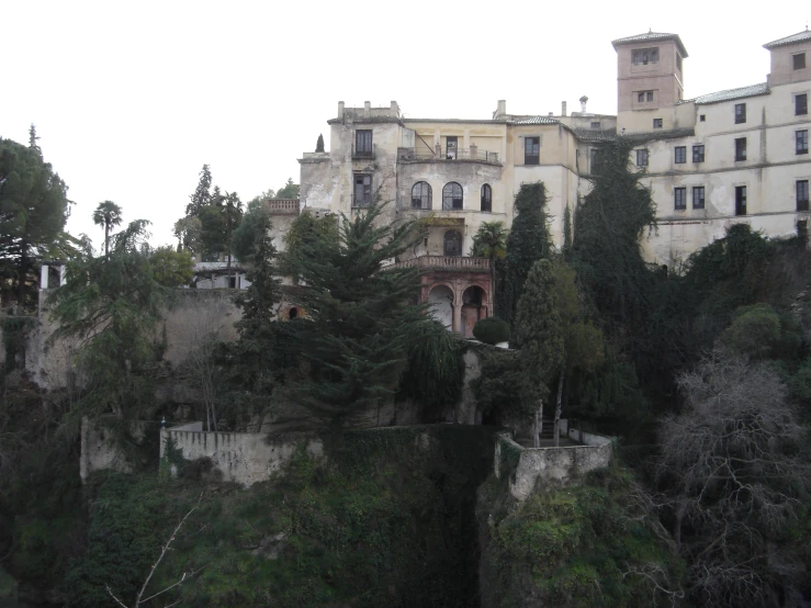 some buildings on the side of a cliff with trees