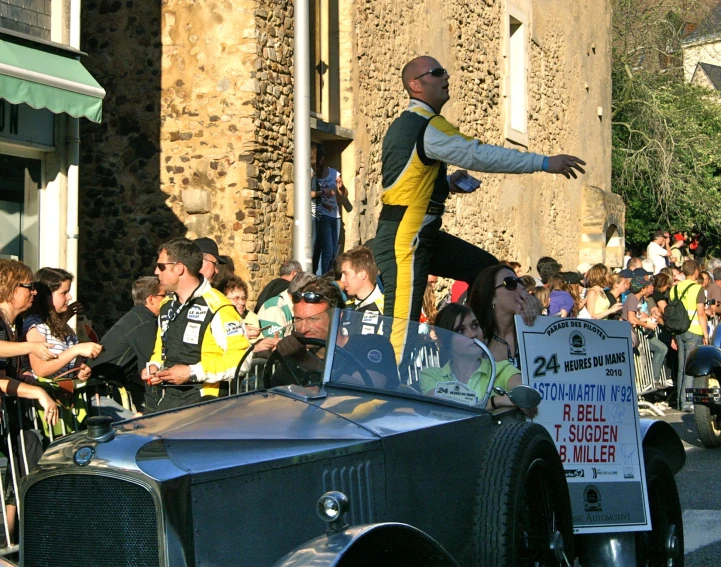 a man standing on the top of an old car