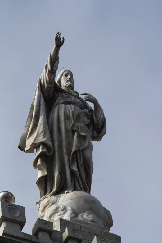 the statue is standing at the base of the hill