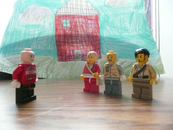 four legos, one wearing an indian outfit, are shown with a background and a piece of art made from pencil