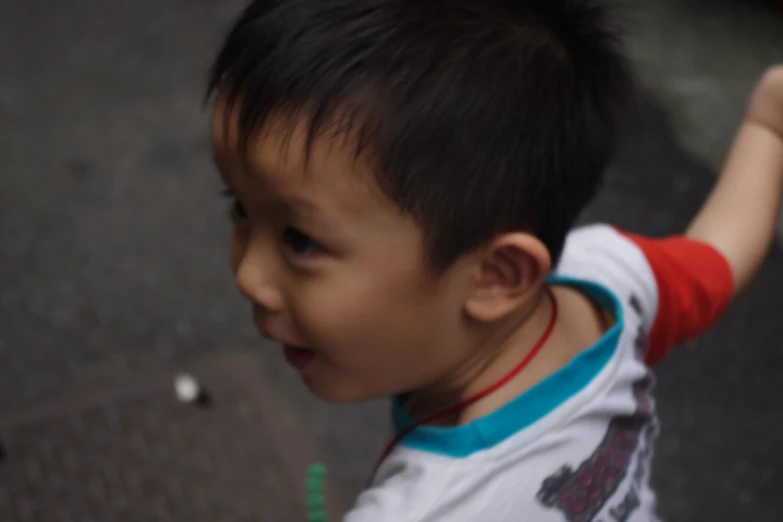 a boy holding an object in his hand on the ground