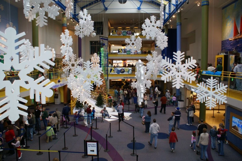 several christmas trees are in the middle of the mall