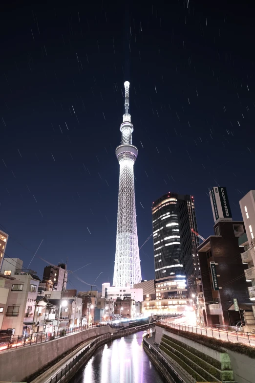 a city has a bright white spire lit at night