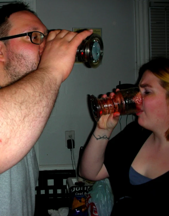 two people drink from glasses, and one man is holding soing up