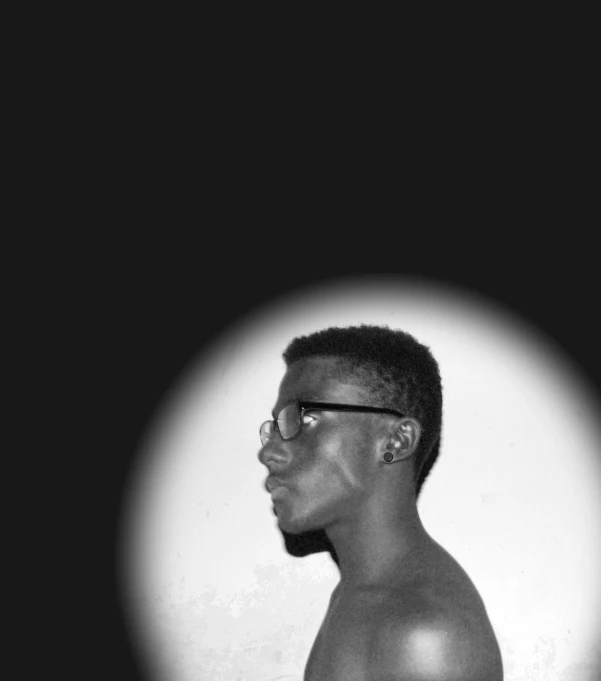 a man wearing glasses looking in the mirror