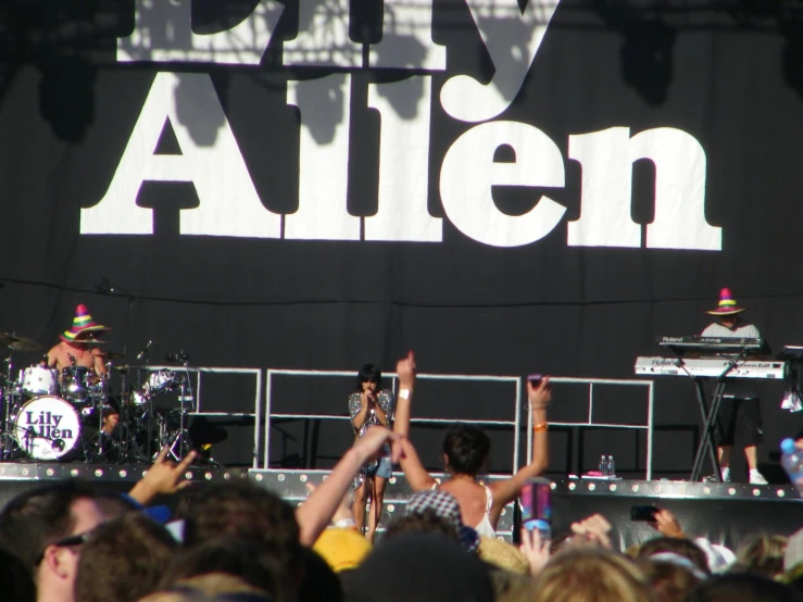 a band playing at a concert and the music is played by a large crowd