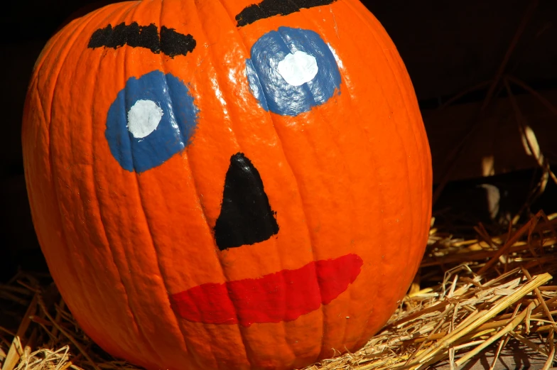 a pumpkin shaped like a face in straw