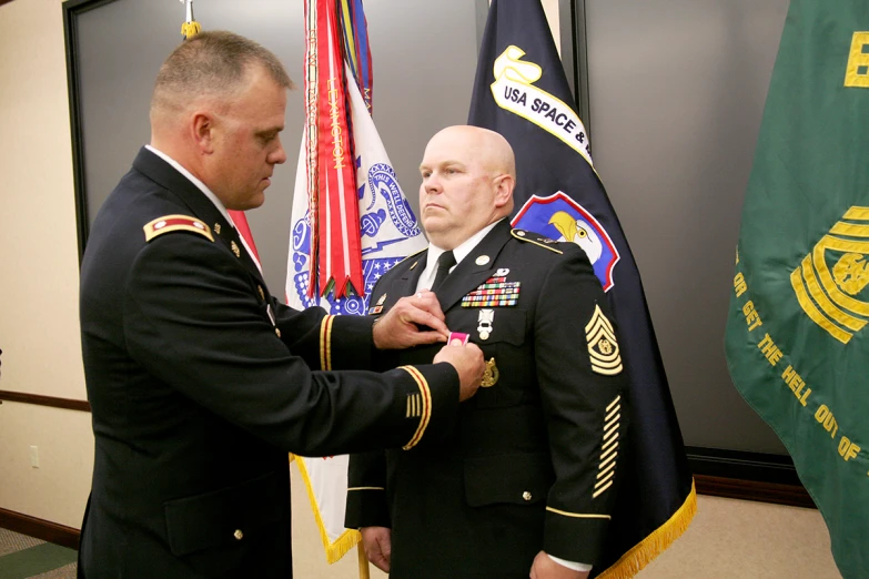 two soldiers are being awarded medals by an official