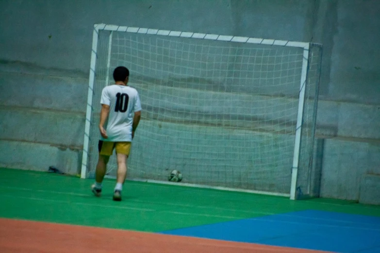 a soccer goalie walking away from the net during a game