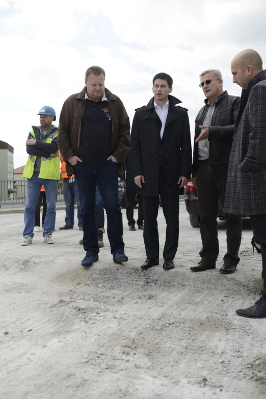 several men talking together as a third watches