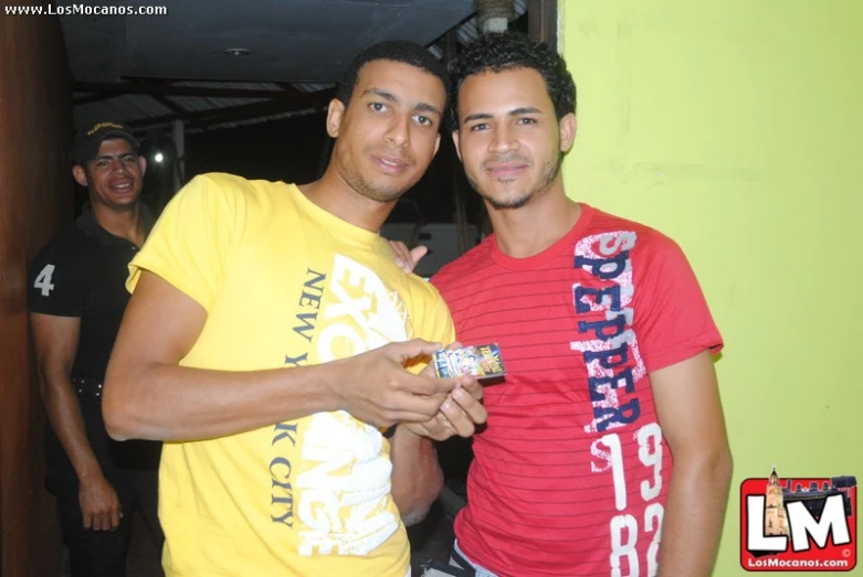 two young men posing for a po while holding a can