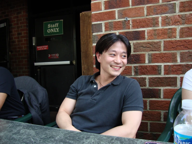 a smiling asian woman sitting in a restaurant