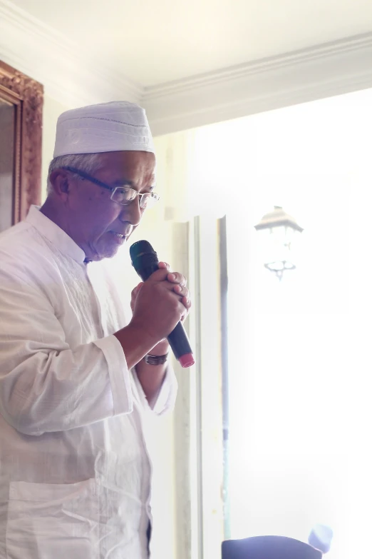 a man in white is holding a microphone