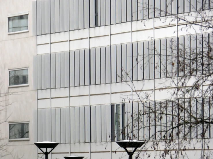 a building with many windows has lamps on the street