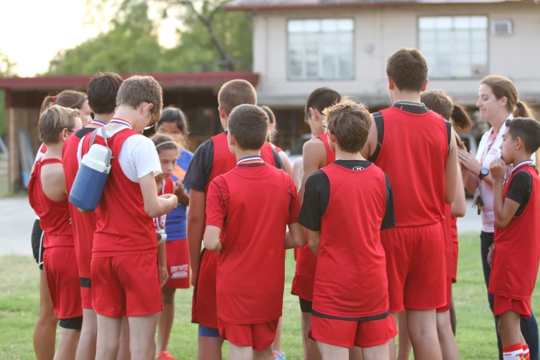 group of children and adults standing together on soccer field