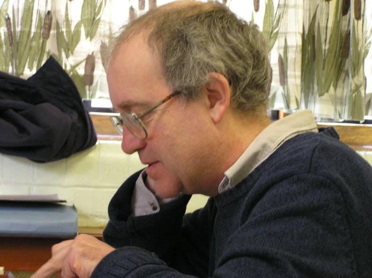 a man sits at a desk using his laptop