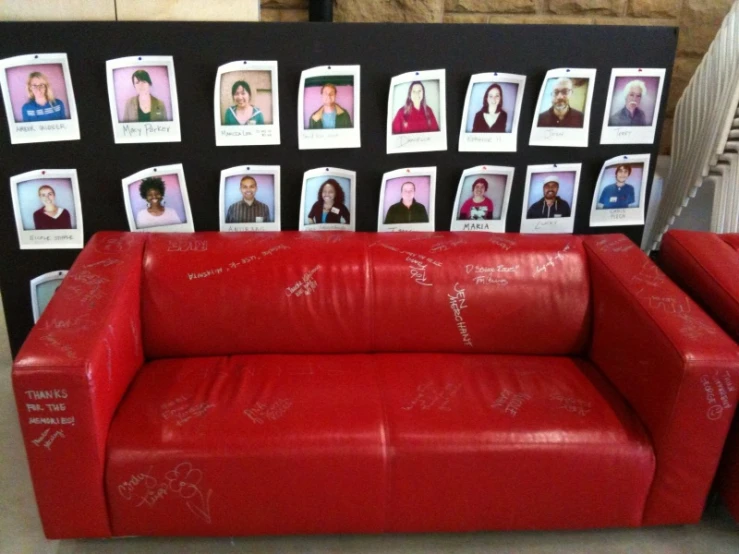 a couch with pos taped to the wall