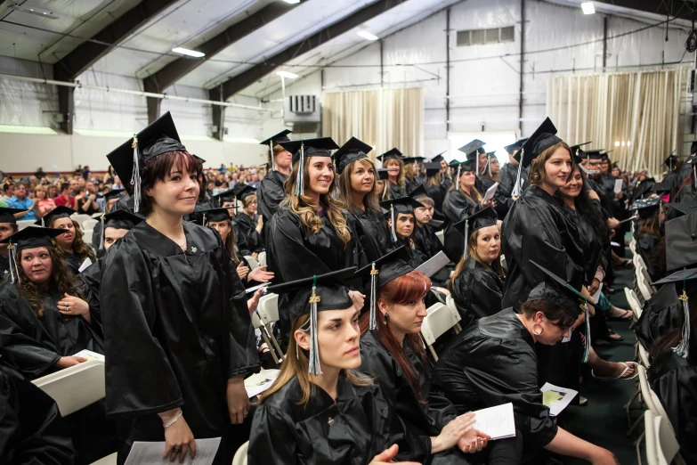 a group of students taking their seats at a graduation ceremony