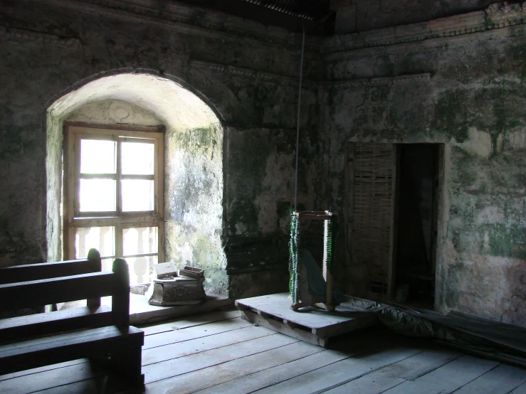 an old room with two benches in front of a window