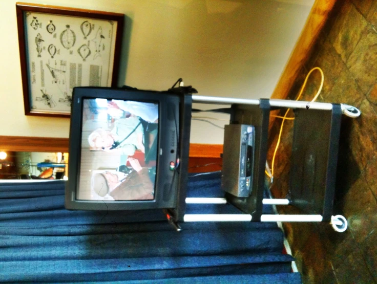 television on a rolling cart with the television underneath