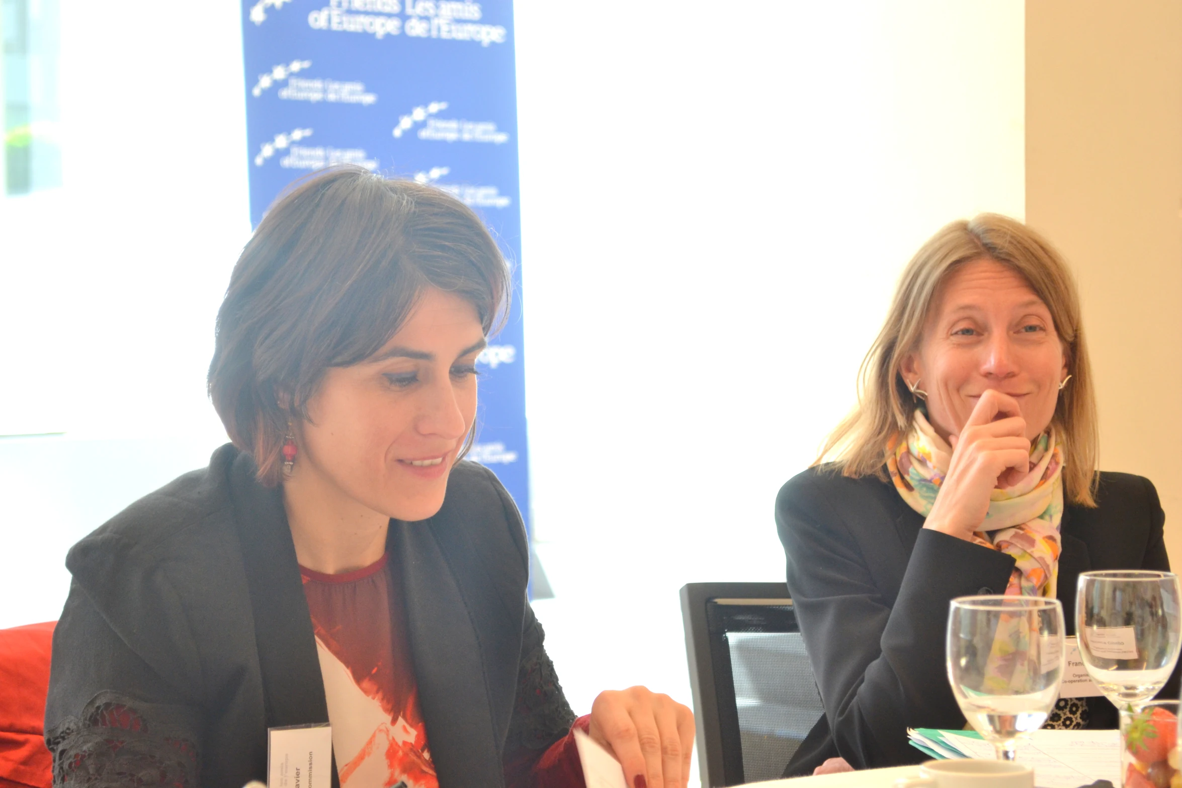 two women at a table with wine glasses in front of them