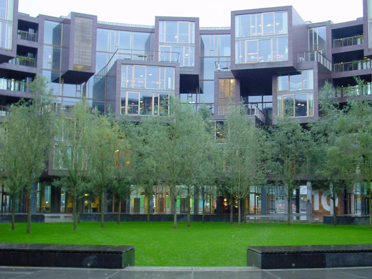 some trees and grass in front of buildings