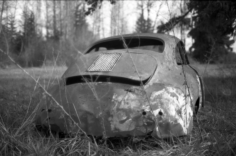 a very old car that is sitting in some grass