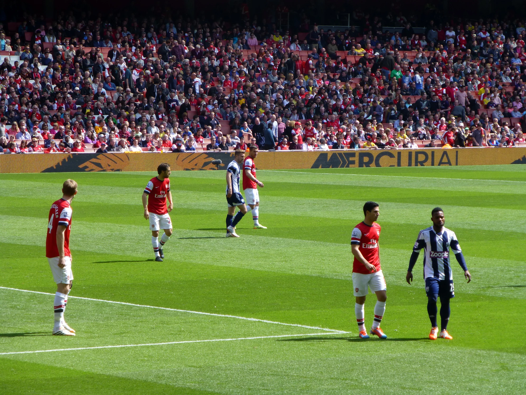 several players in red and white on a green field