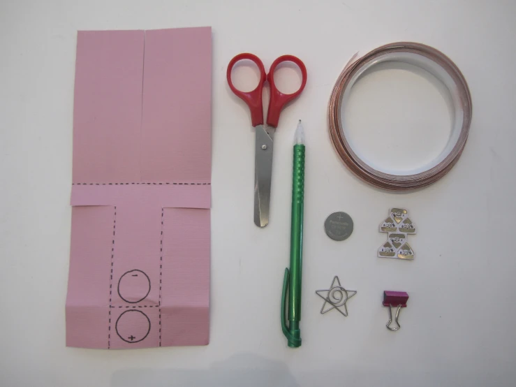 a pair of scissors, pins and other items are shown