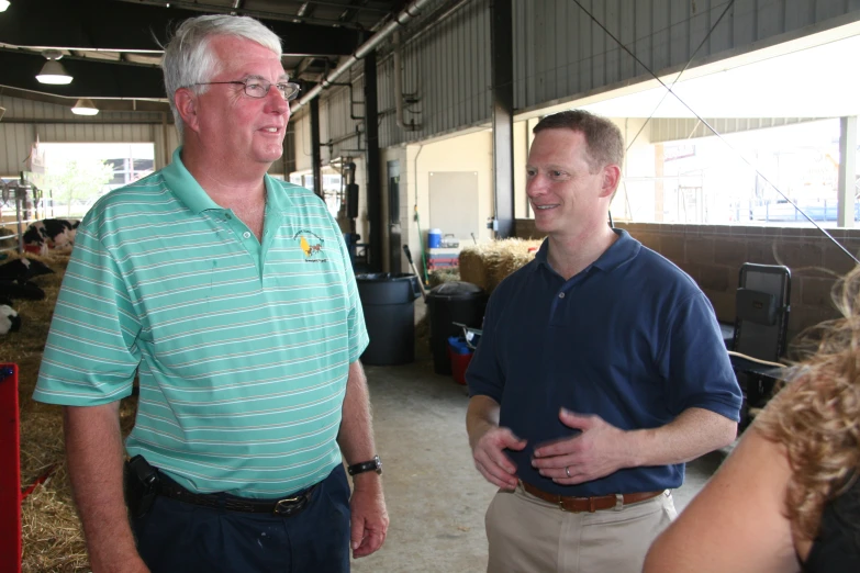 two men standing next to each other in a warehouse