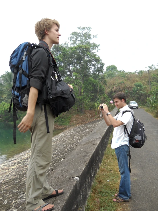 a man takes a picture with his cell phone while the cameraman looks at him