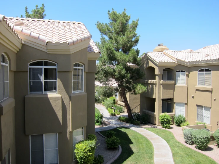 three buildings on a sidewalk lined with grass