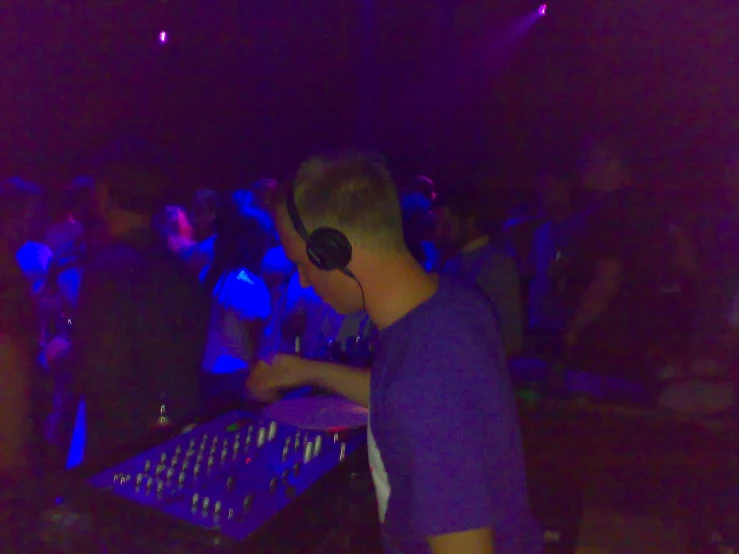  wearing headphones recording and mixing music in a club