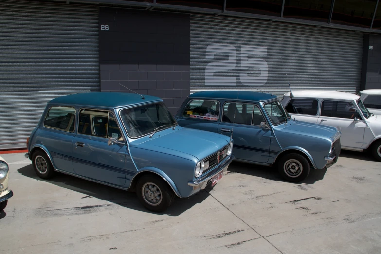 two old cars parked side by side in front of a building