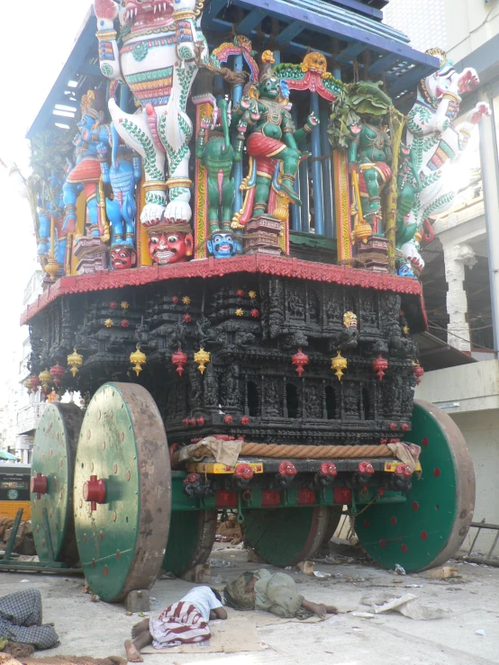 a large ornate wooden horse cart in front of a building